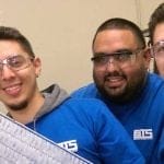 Four Brownson students wearing blue Brownson shirts smile at the camera
